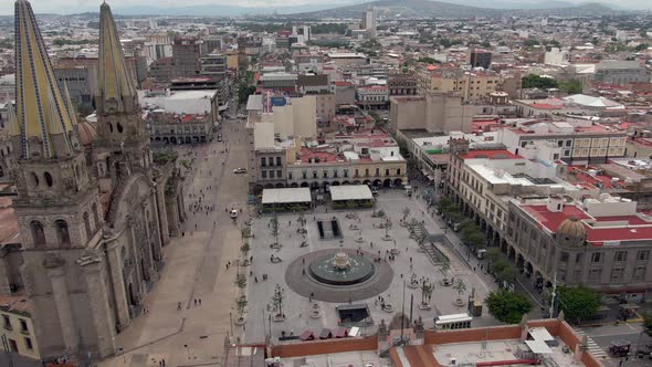 People Walking At Plaza Adjacent To Guadalajara Cathedral In Jalisco, Mexico. - forward aerial, tilt