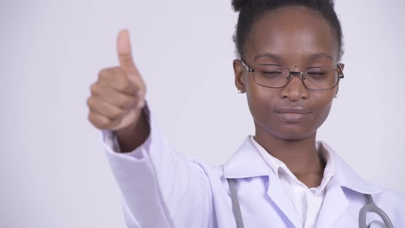 Face of Young Happy African Woman Doctor Giving Thumbs Up