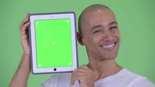 Face of Happy Handsome Bald Man Showing Digital Tablet