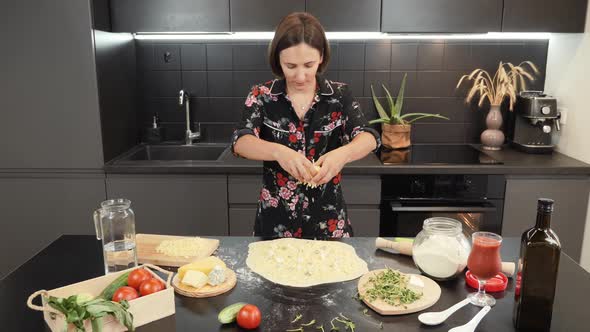 Cooking pizza at home. Woman making cheese pizza in domestic modern kitchen