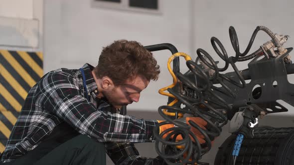 Young Mechanic Repairing a Truck in Auto Repair Shop