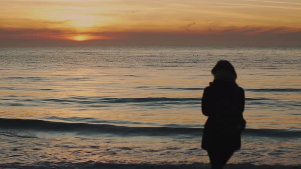 Silhouette of a Young Woman on a Background of the Sea