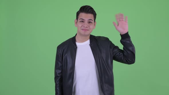 Happy Young Multi Ethnic Man with Leather Jacket Waving Hand