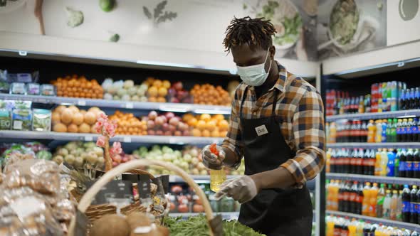 African American Worker Refreshing and Arranging Greens in the Store