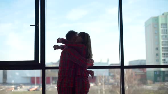 Silhouettes of Hugging Couple in Front of Window
