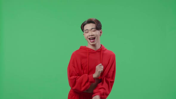 The Smiling Asian Transgender Male Dancing While Standing On Green Screen In A Green Screen Studio