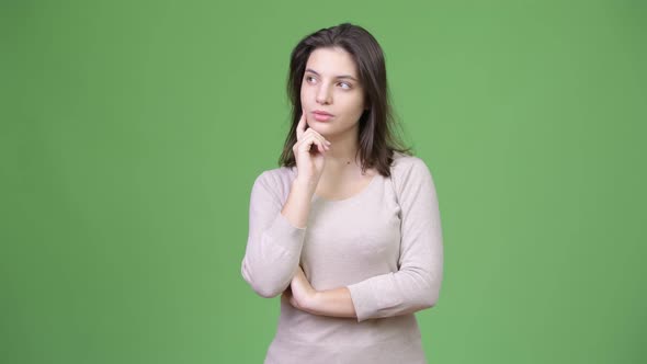 Young Beautiful Woman Thinking Against Green Background