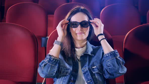 A Lady Puts on 3D Glasses While Watching a Movie