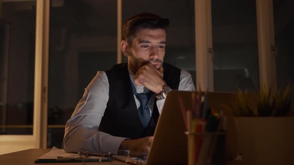 Caucasian businessman working on a laptop late night in the office. Businessman Stressed.