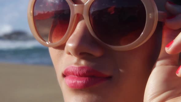 Young woman adjusting sunglasses