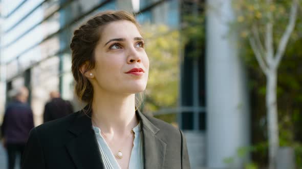 Young business woman walking on the street talking on her mobile phone