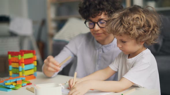  Child Drawing Picture with Pencils While Mother Talking and Smiling