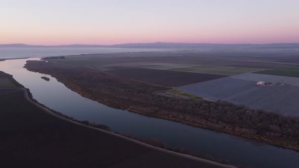 Salinas river flowing into Monterey bay with flat farm fields landscape around. High angle aerial vi