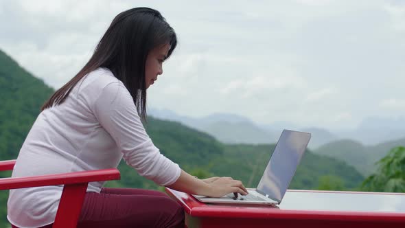 Woman Typing On Laptop With Beautiful View