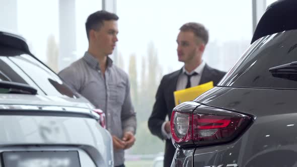 Selective Focus on a Car, Male Customer Talking To Auto Dealer on the Background