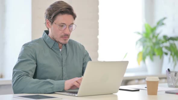 Attractive Middle Aged Man with Laptop Looking at Camera