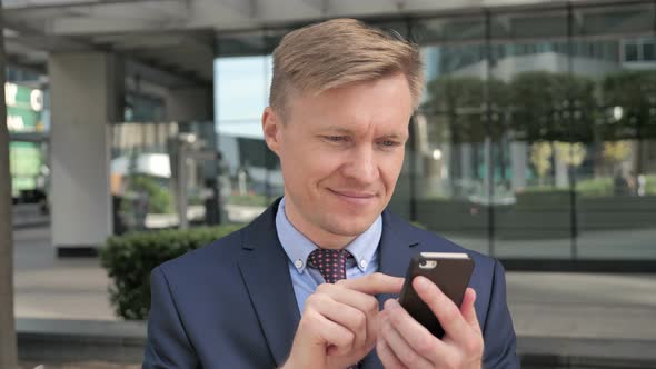 Businessman Typing Message on Smartphone