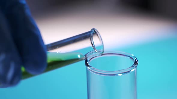 In a Laboratory, a Scientist with a Pipette Analyzes a Colored Liquid To Extract the DNA and