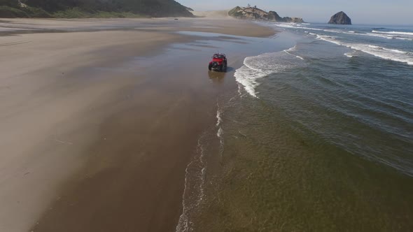 Aerial shot of 4x4 off road vehicle driving on beach