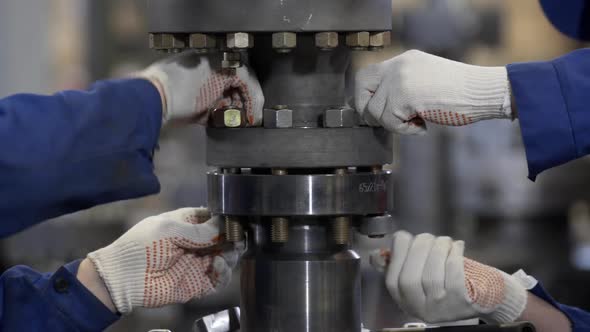 Oil and Gas Wellhead Tree Equipment Production Plant. Worker Assembles of Wellhead Fitting. Modern