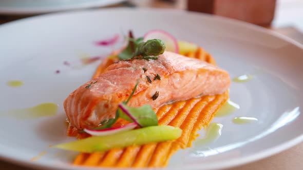 Salmon fish fillet grilled for dinner in seafood restaurant and served on white plate