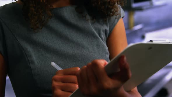 Restaurant manager writing on clipboard