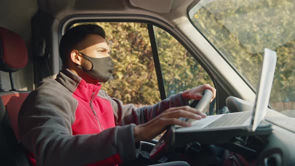 Young Indian Man with Face Mask Using Laptop in the Van