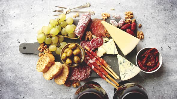 Cold Snacks Board with Meats, Grapes, Wine, Various Kinds of Cheese