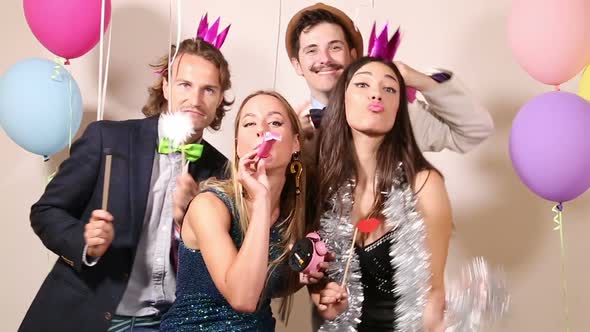 Group of friends having a great time in party photo booth