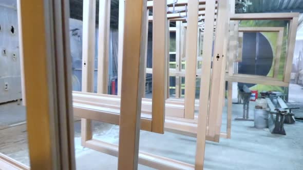 Wooden window frames prepared for painting in the workshop.