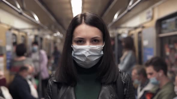 A girl on a city subway train wearing a medical mask for coronavirus.