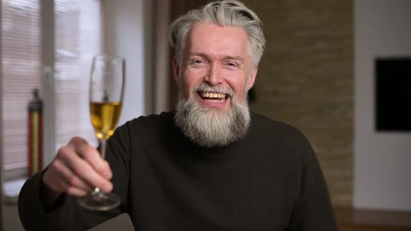 smiling gray-haired bearded man who congratulates via video communication