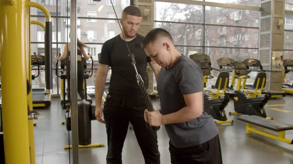 Disabled Young Man with Instructor Working Out in Gym
