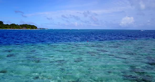 Wide overhead tourism shot of a white sand paradise beach and blue sea background in high resolution