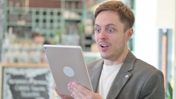 Portrait of Young Man Celebrating Success on Tablet