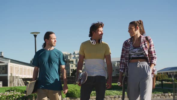 Happy caucasian woman and two male friends spending time together on sunny day