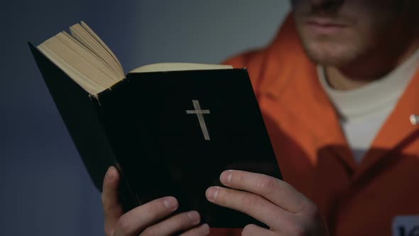 Prisoner in Handcuffs Reading Holy Bible