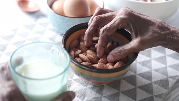 Close Up Senior Women Hand Holding a Bowl on Almond