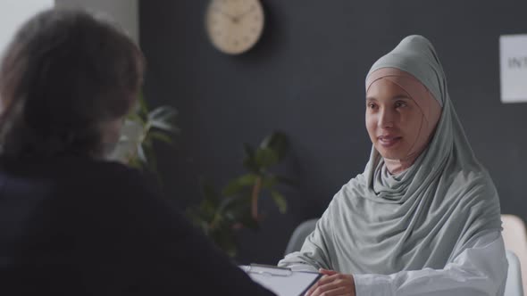 Positive Muslim Woman in Hijab Posing for Camera on Job Interview