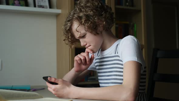 Worried Adorable Little Girl Looking at Smartphone Screen Dissatisfied with News Message Sitting at