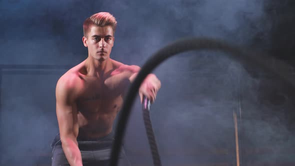 Bodybuilder Practice Effective Way To Burn Calories. Battle Rope Training in Gym