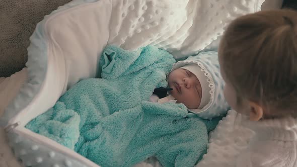 Cute Sister Kisses Junior Brother Sleeping on Soft Blanket