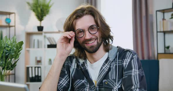 Freelancer which Looking Into Camera with Happy Face Expression Taking off His Glasses