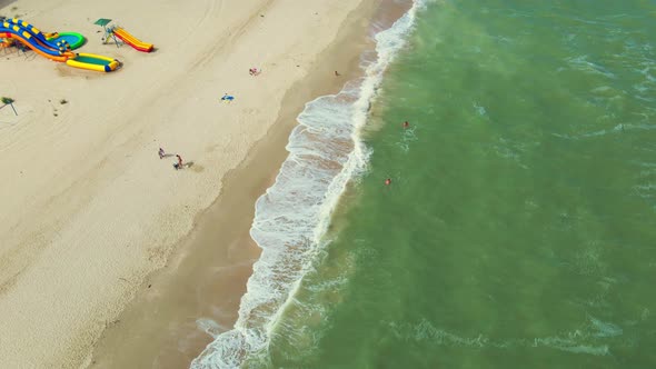 Aerial Point of View To Sandy Seaside with Resorts, Sun Umbrellas and Attractions on Beach.