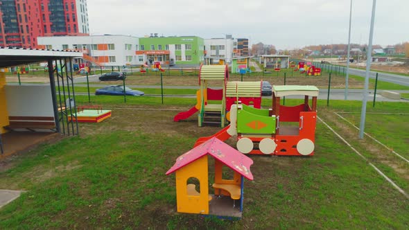 Small House and Slides on Green Lawn in Yard of Kindergarten