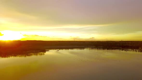 Beautiful Forest Lake Sunset Aerial with Vibrant Fall Season Colors Establishing Panning Shot