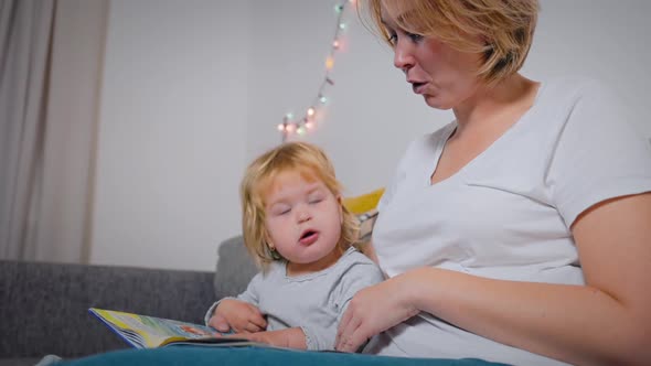 Young mother is engaged in reading with her a little autistic child.