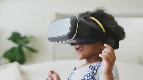 Smiling african american girl playing with vr headset in living room