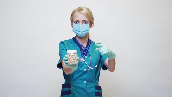 Medical Doctor Nurse Woman Wearing Protective Mask and Rubber or Latex Gloves - Holding Pills