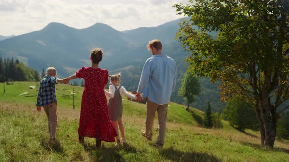 Back View Family Walking on Mountains Hill Sunny Day